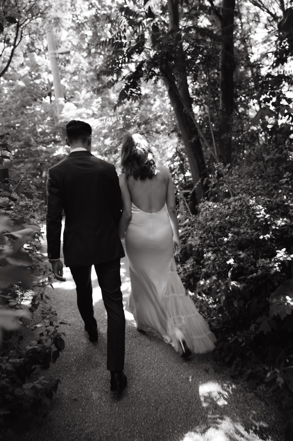 Black and white candid photo of the bride and groom, walking in the garden captured by Jenny Fu Studio.