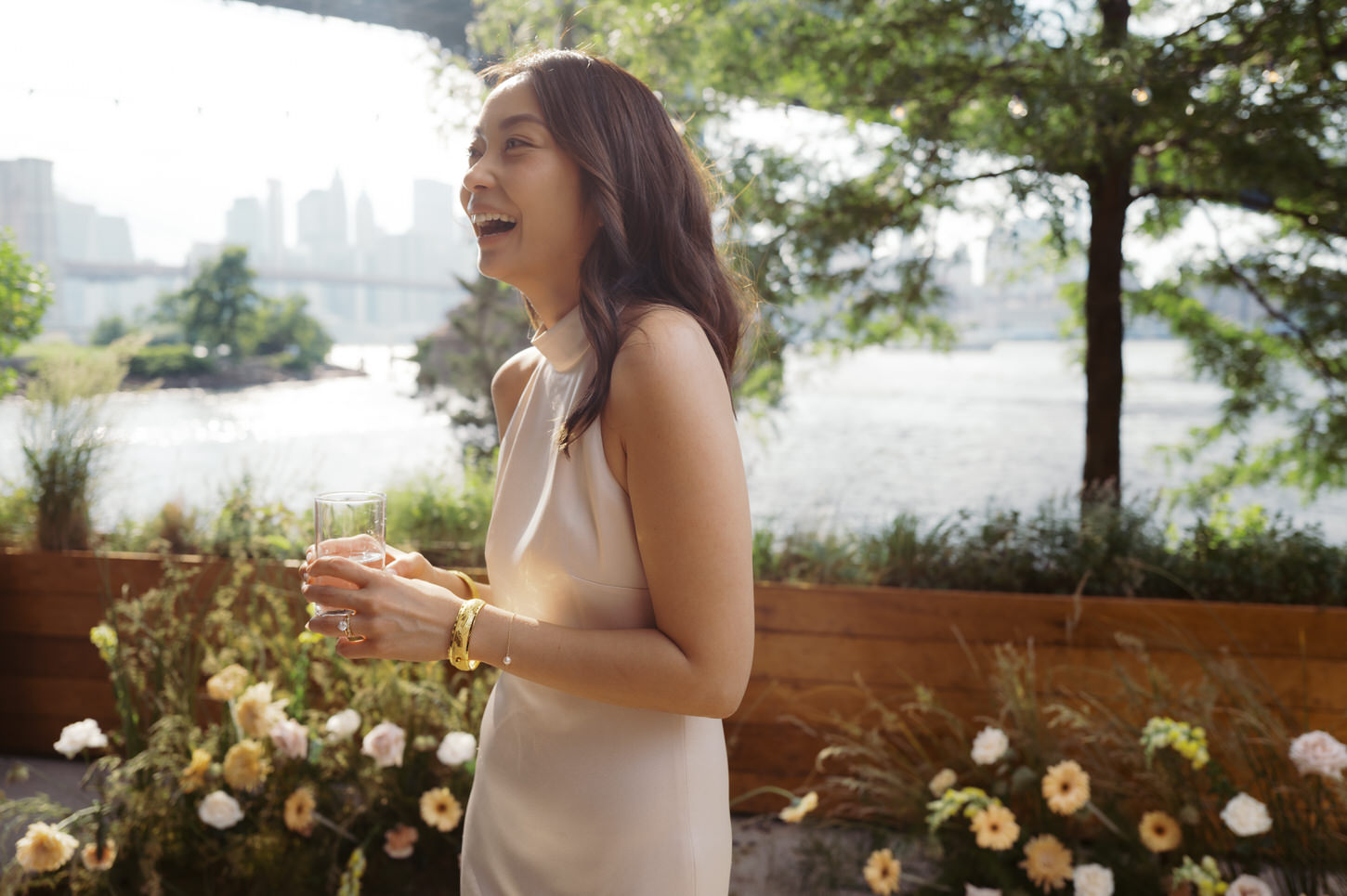 A light and happy photo of the bride with pretty flowers in the background, captured by Jenny Fu Studio.