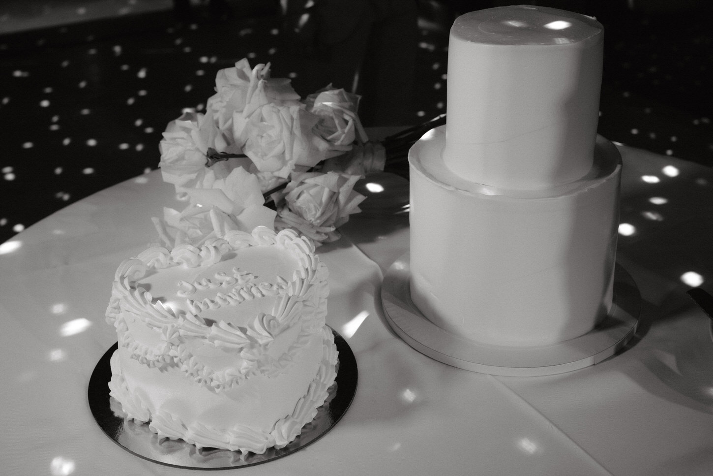 Black and white image of the white petite wedding cakes and white flowers, captured by Jenny Fu Studio.