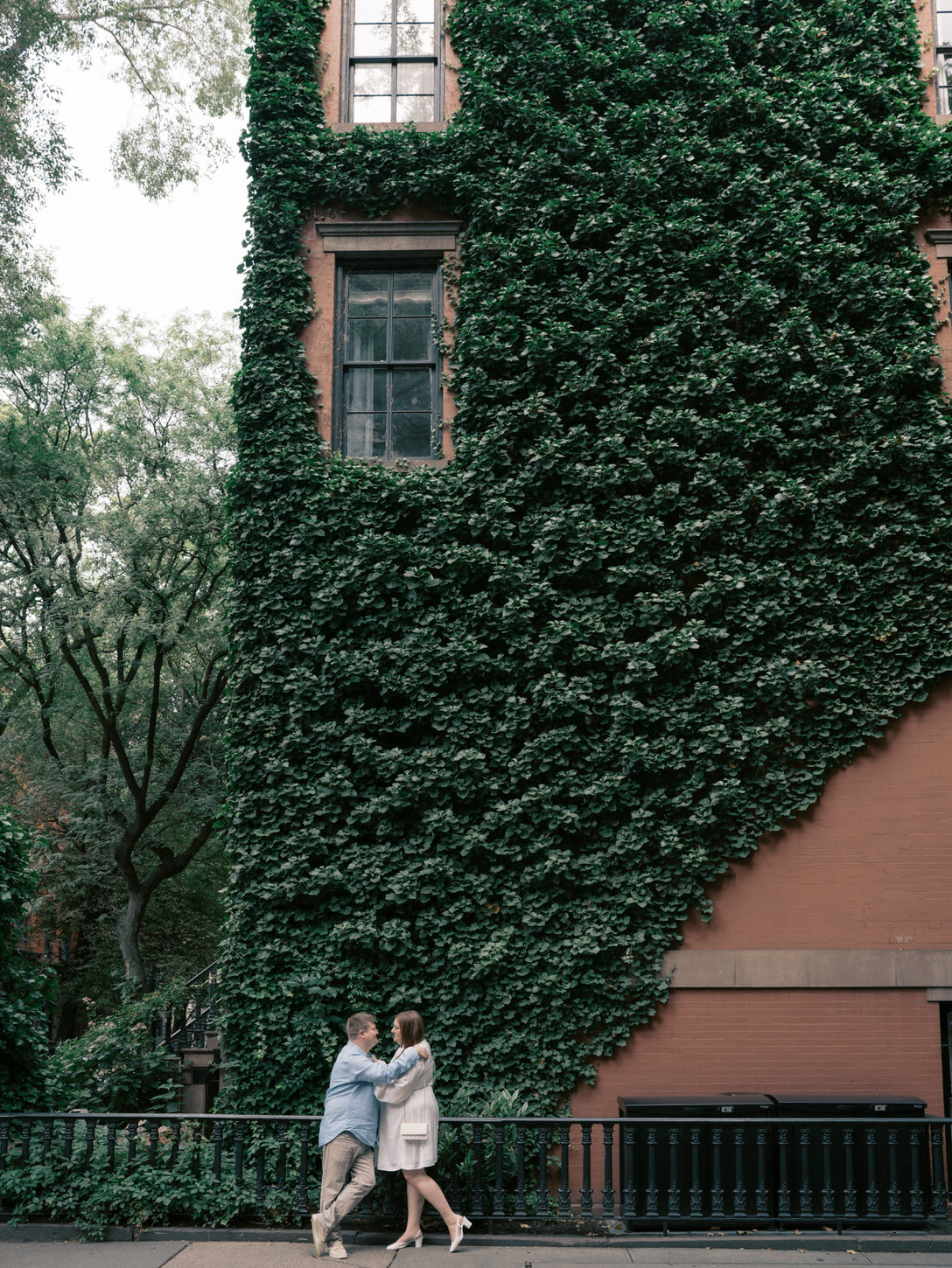 The engaged couple are hanging out in front of a beautiful ivy-covered building in West Village, NYC, captured by Jenny Fu Studio.