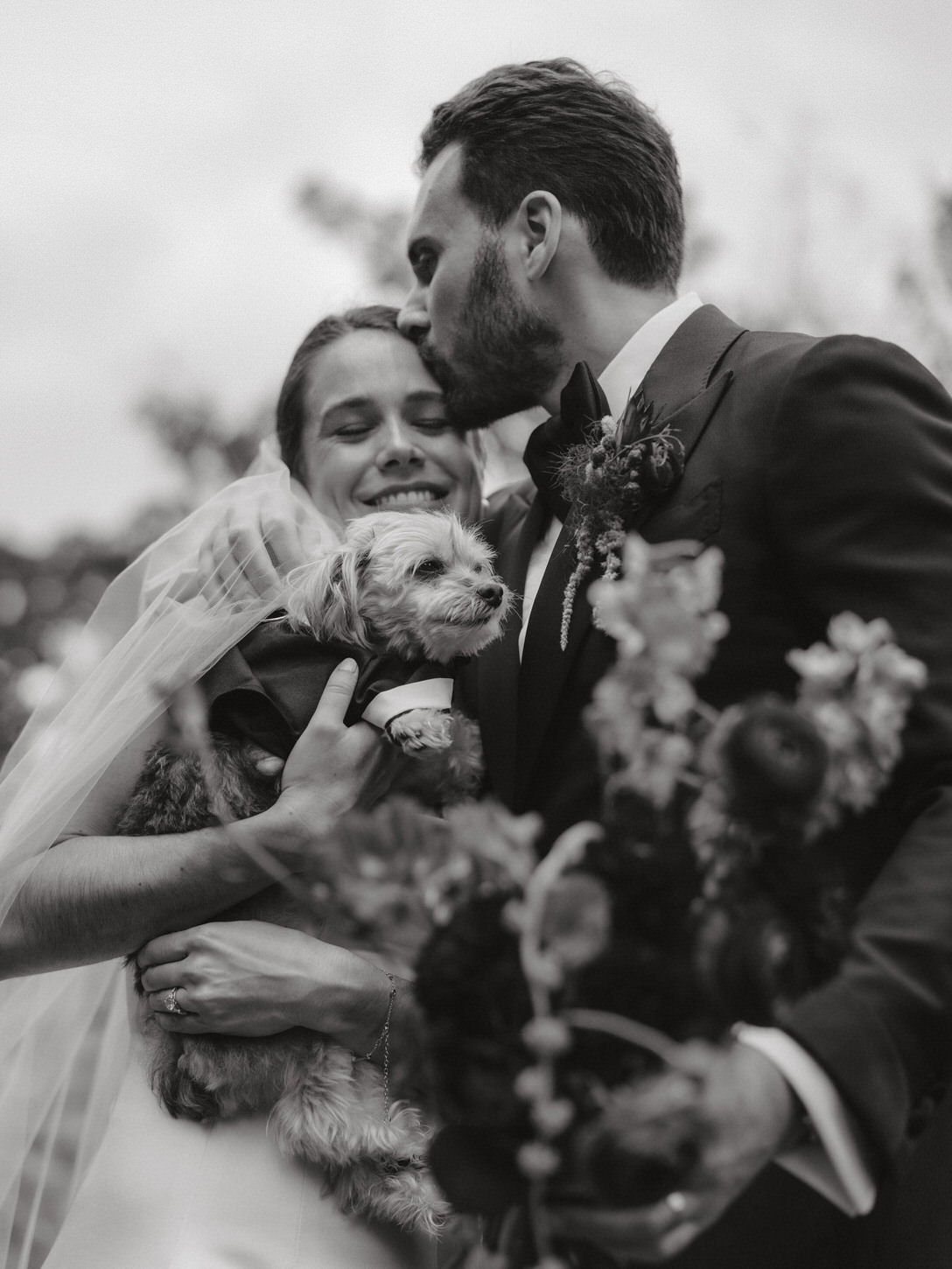 The groom is lovingly kissing the bride on her forehead, captured by high-fashion wedding photographer, Jenny fu Studio.