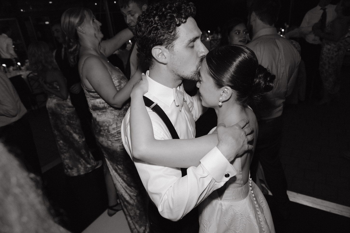A heartfelt gesture of the groom as he kiss the bride on the forehead while dancing, captured by Jenny Fu Studio NYC.