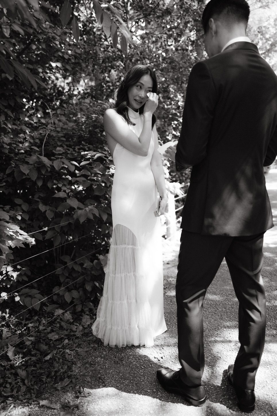 The bride is emotional as the groom reads his letter to her before the wedding ceremony, captured in documentary black and white by Jenny Fu Studio, NYC.