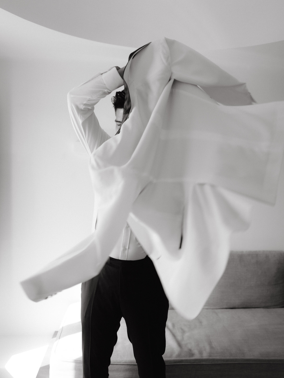 The groom is getting ready for his high-fashion destination wedding in Santorini, Greece, captured in black and white by Jenny Fu Studio.