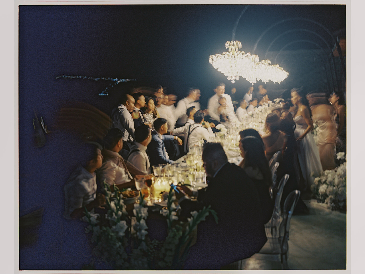 A distorted image of an intimate wedding reception in Santorini, Greece, captured by destination wedding photographer, Jenny Fu.
